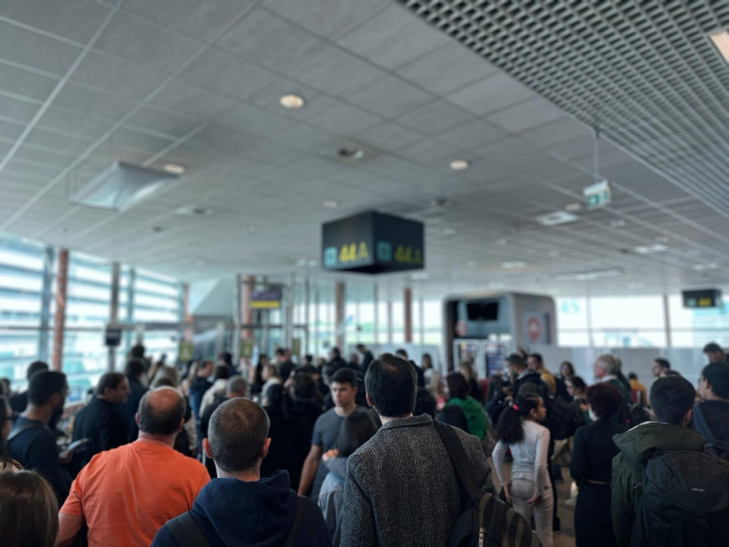 Passengers crowding around a gate at Lisbon Airport