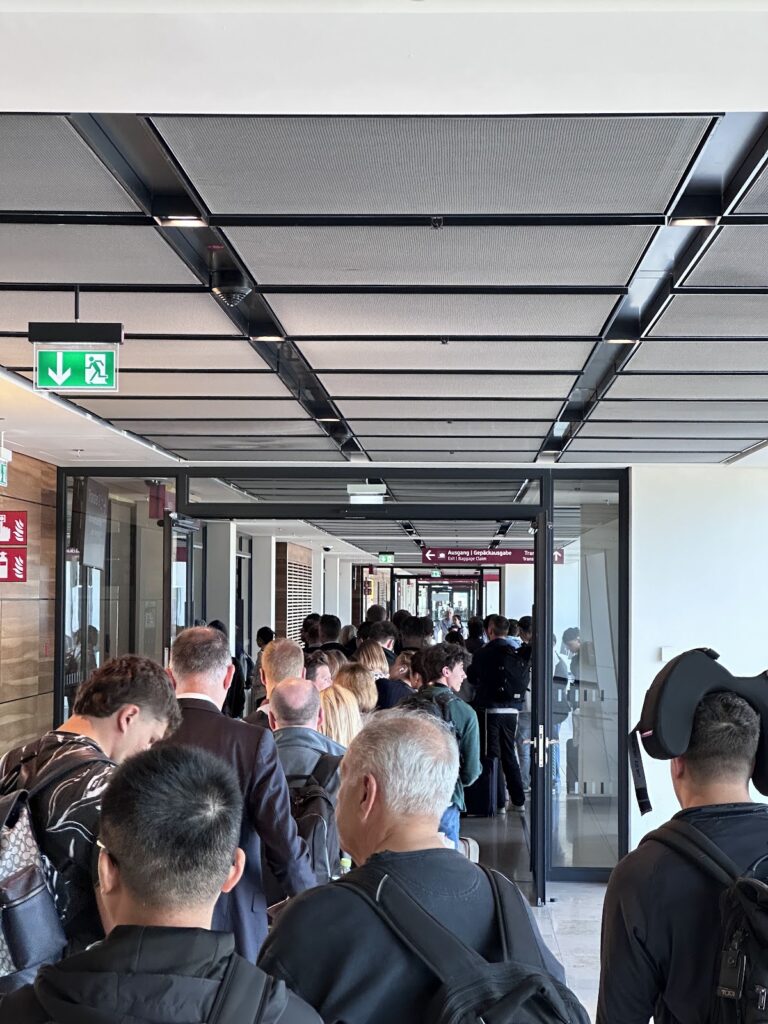 Crowds funnelling through tight doorways at Berlin Brandenburg Airport (BER)