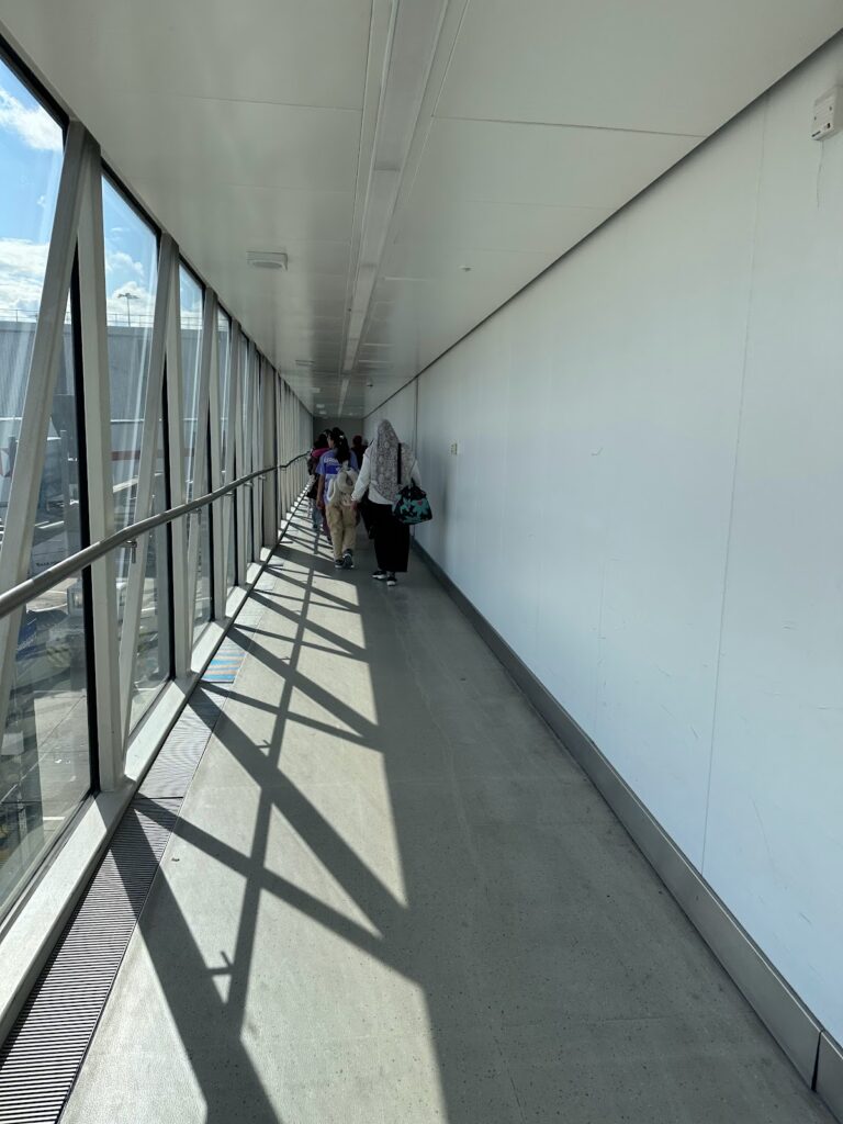 Passengers walking through jet bridge at Heathrow