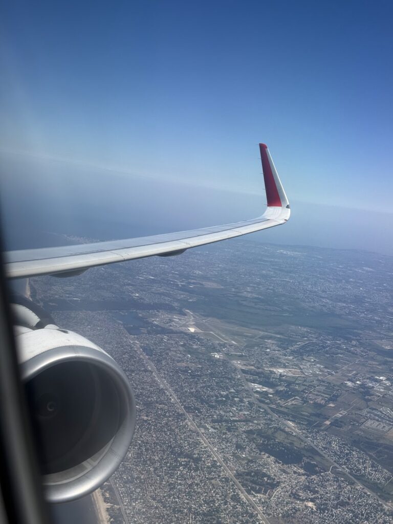 LATAM A321 wing view over Montevideo after takeoff