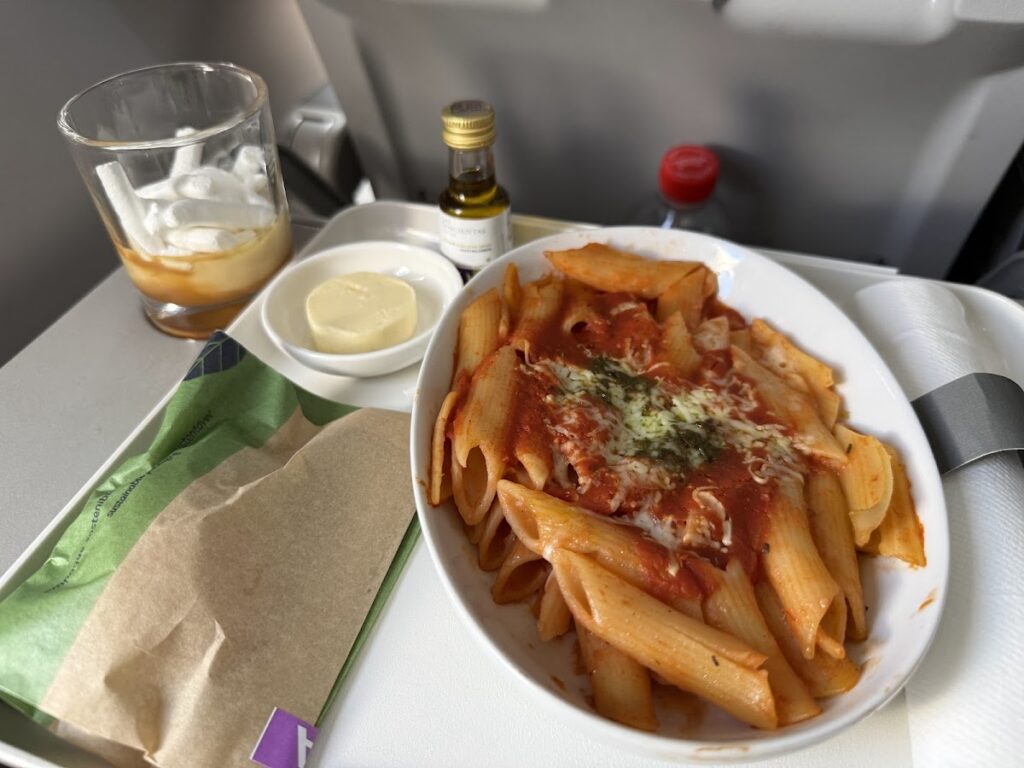 Pasta meal served in LATAM A321 Premium Economy cabin