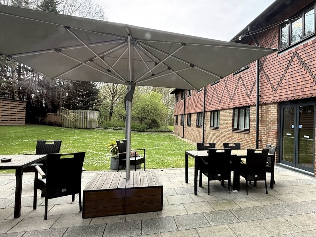 Outdoor patio seating area with garden and parasols