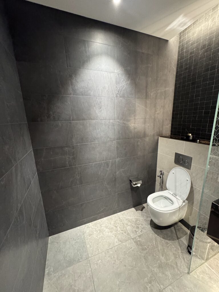 Dark-tiled bathroom inside Etihad First Class Lounge
