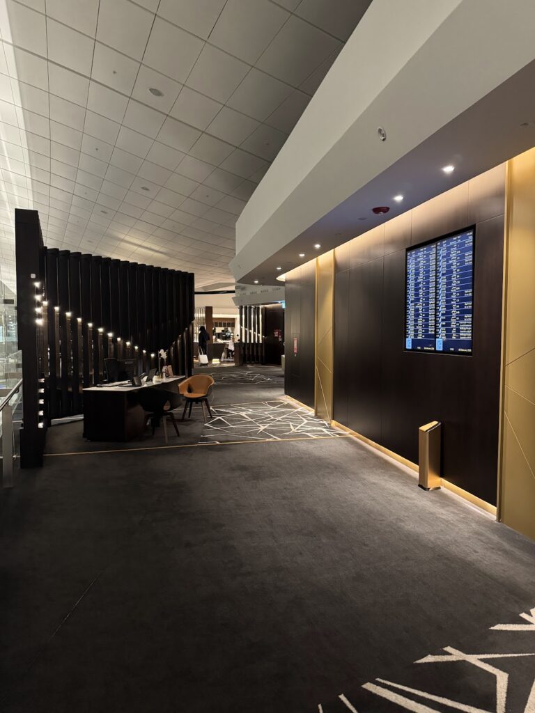 Etihad First Class Lounge entrance with flight information board