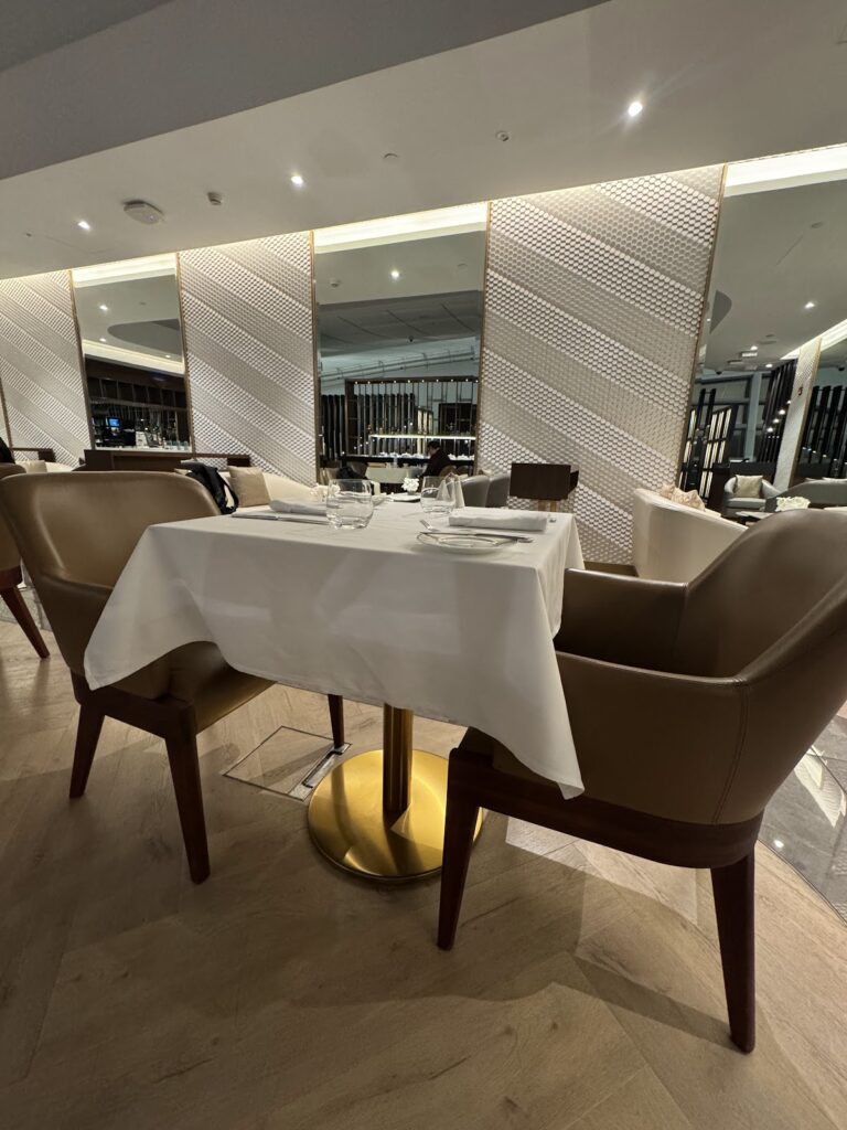 White-linen dining table in Etihad First Class Lounge restaurant