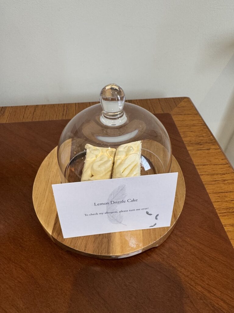 Complimentary lemon drizzle cake under glass cloche