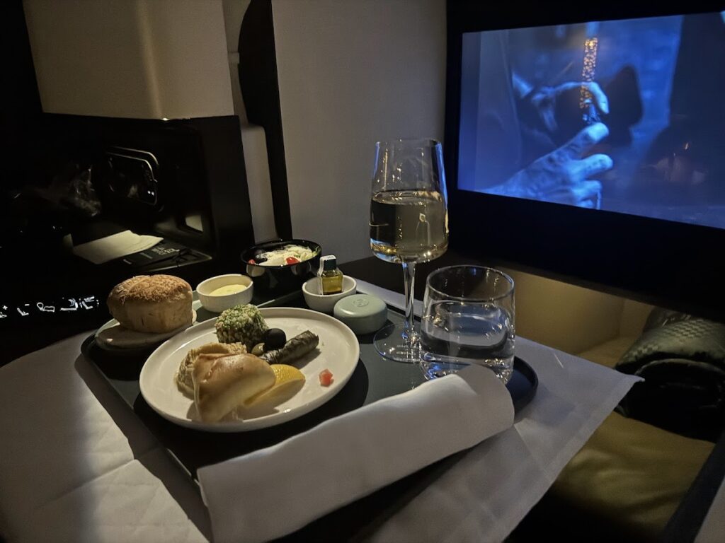 Etihad Business Class dinner with champagne and movie