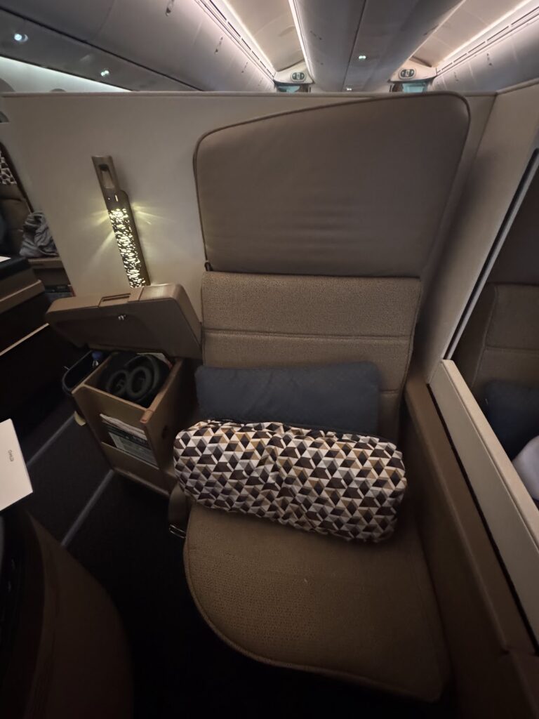 Etihad Business Class window seat with cushion and headphones