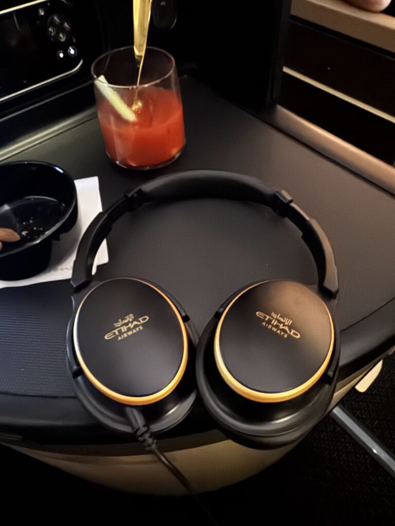Etihad-branded noise-cancelling headphones with a cocktail