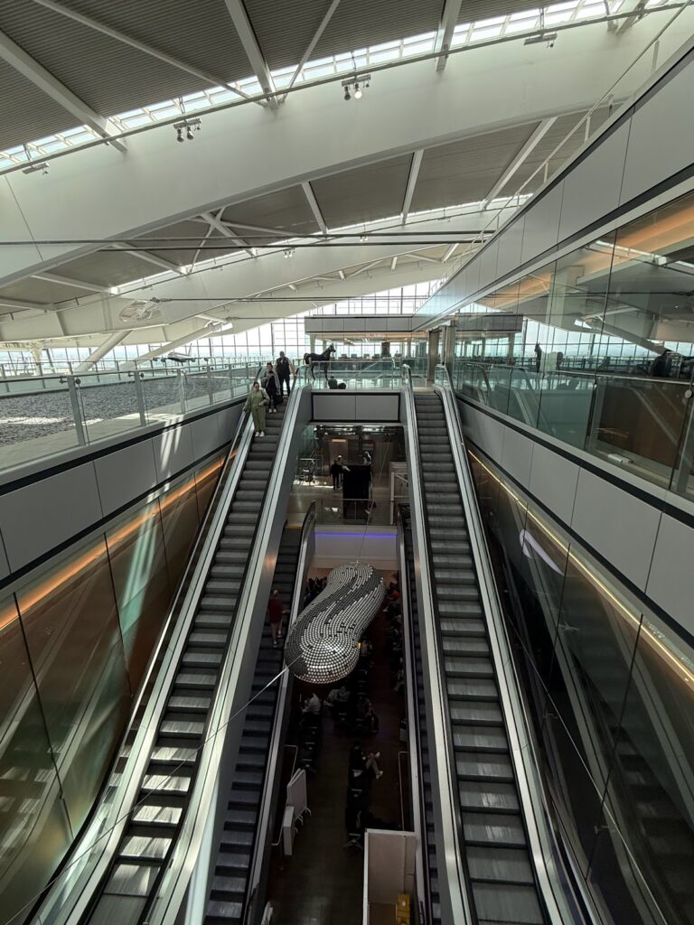 Escalators inside Heathrow terminal with passengers