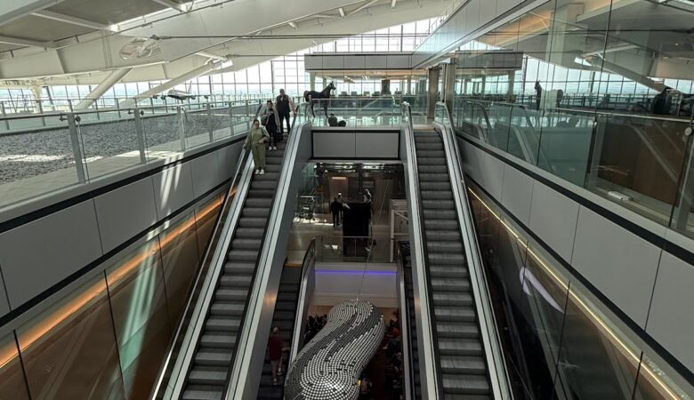 Escalators inside Heathrow terminal with passengers