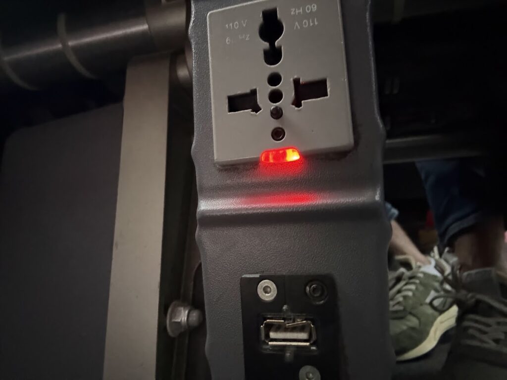 Seat power outlet and USB port below armrest