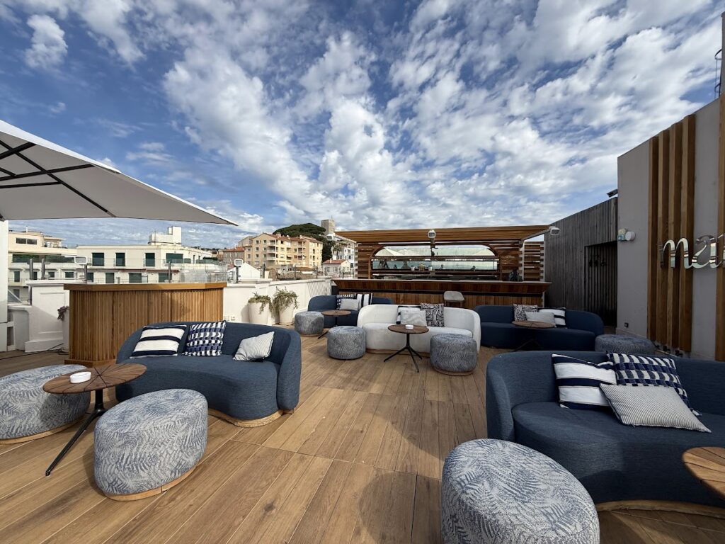 Rooftop terrace seating under a dramatic Cannes sky