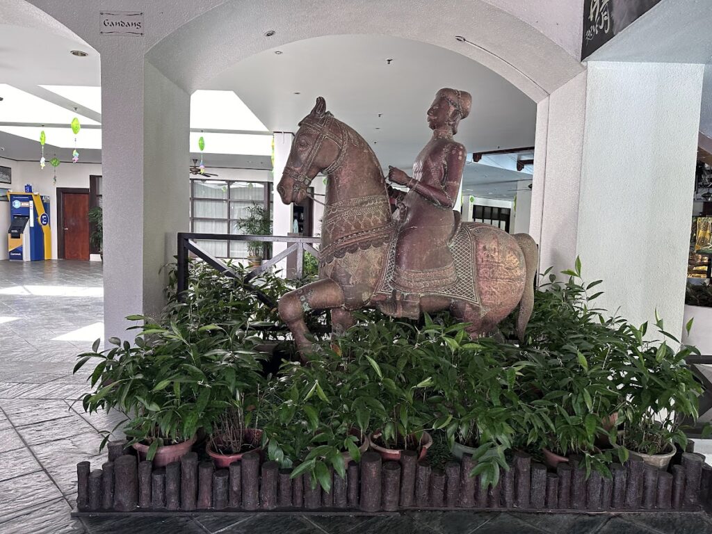 Horse rider statue surrounded by lobby plants