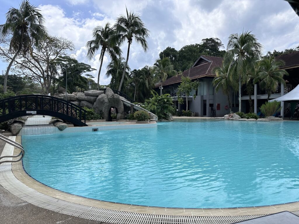 Large Sabah Hotel pool with palms and bridge