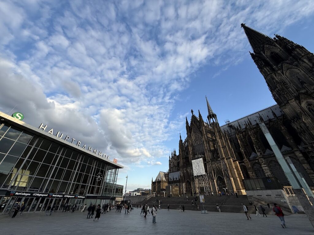 Cologne Hauptbahnhof beside Cologne Cathedral under cloudy sky