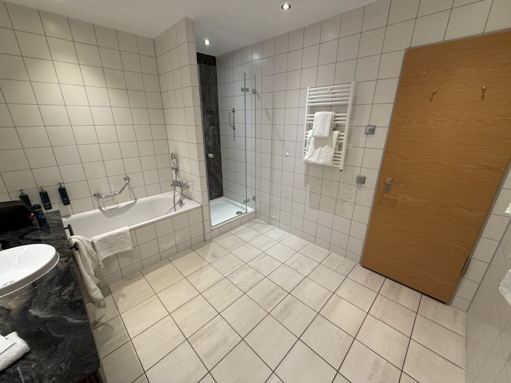 Hilton Cologne bathroom with bathtub and walk-in shower