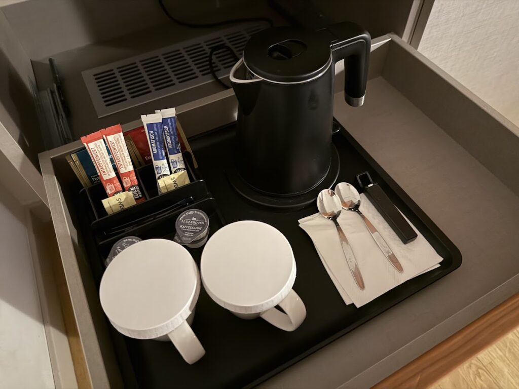 In-room tea tray with kettle, mugs, and supplies