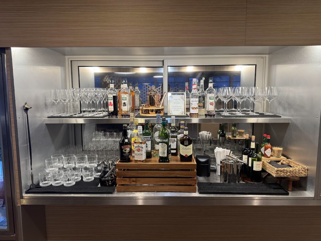 Self-serve bar with spirits, wine, and glasses