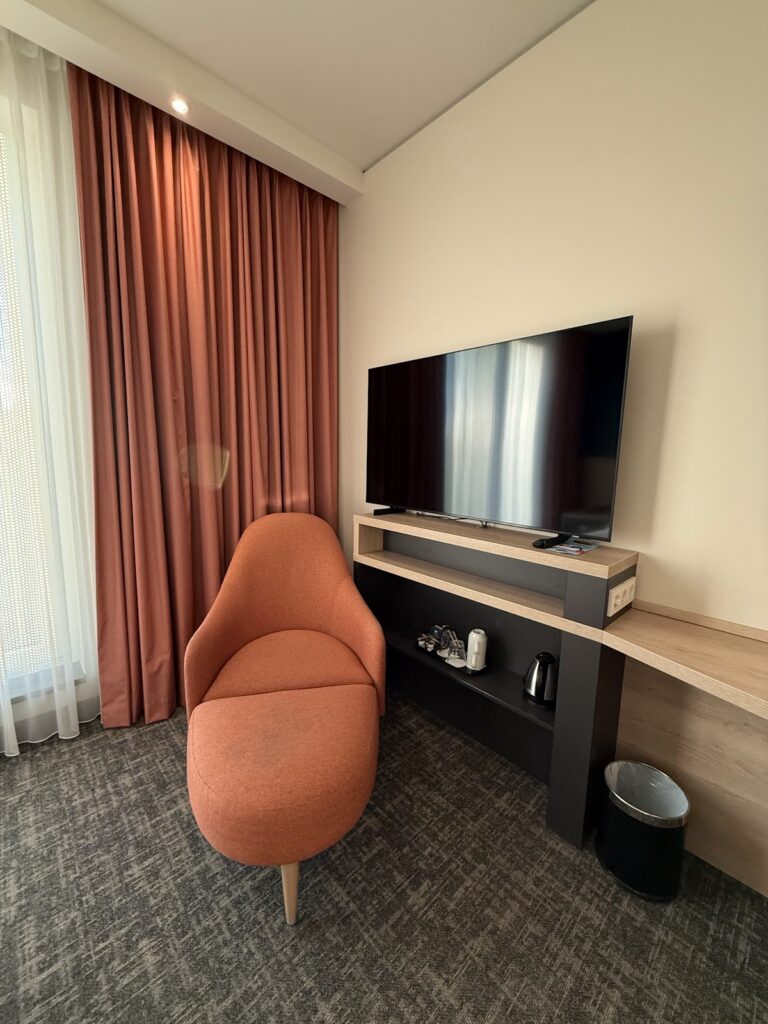 Guest room chair, television, and desk area