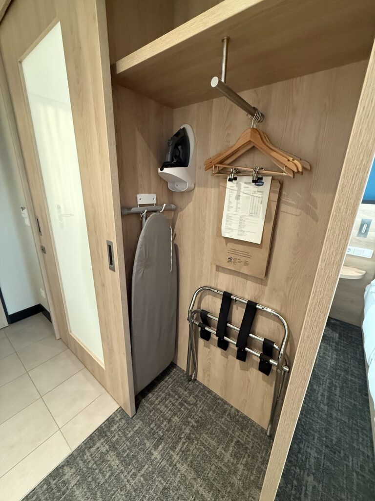 Open wardrobe with iron and luggage rack
