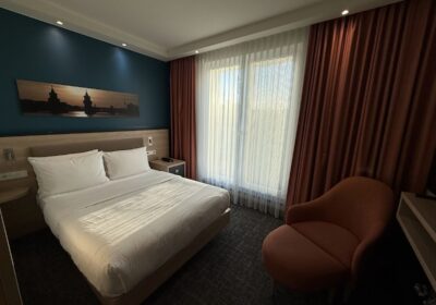 Double bed and orange chair in Hampton Berlin Alexanderplatz room