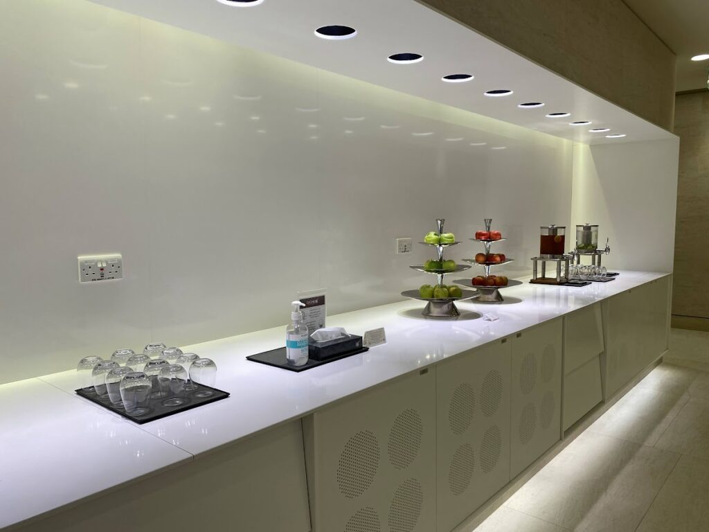 Self-service refreshment counter with fruit and drinks