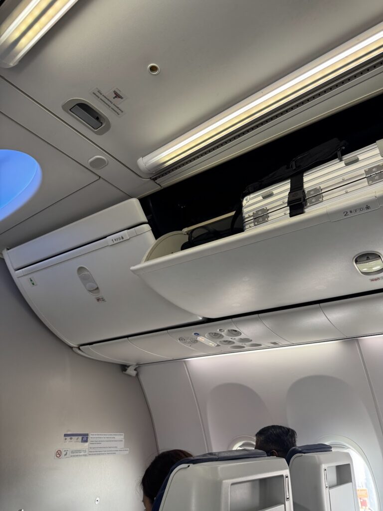 Open overhead bin above Malaysia Airlines 737 cabin