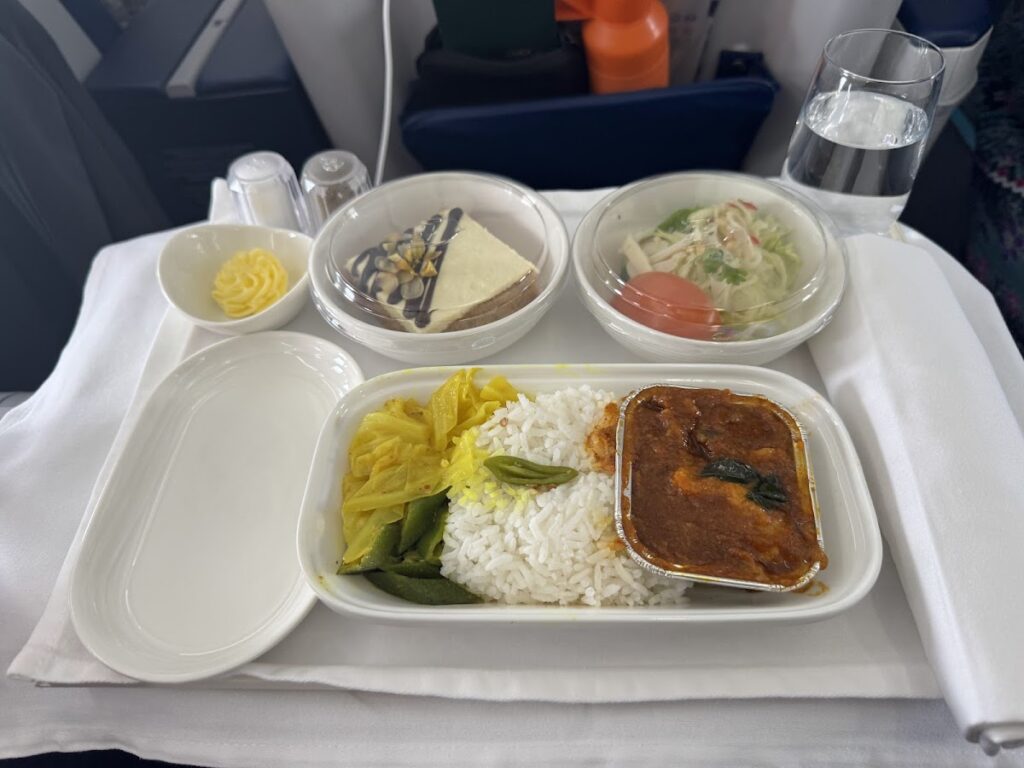 Business Class meal tray with curry, rice, salad, dessert
