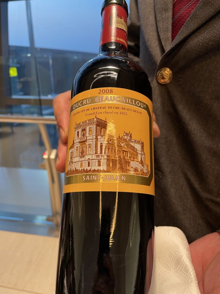 Staff presenting 2008 Château Ducru-Beaucaillou wine bottle