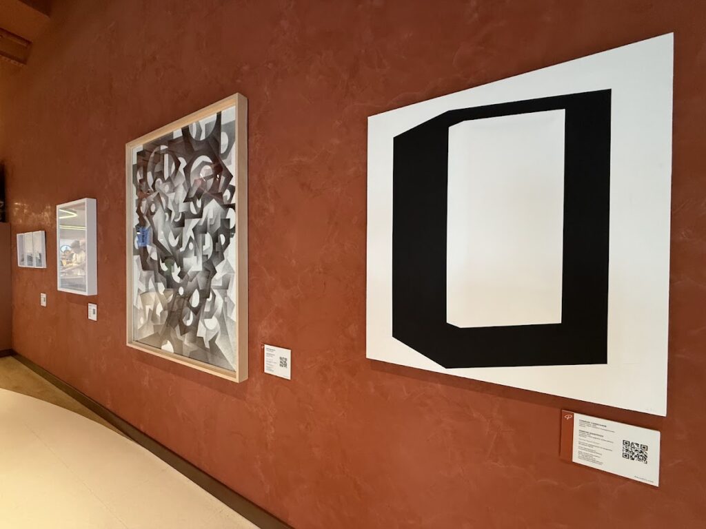 Contemporary art display on terracotta wall inside Primeclass Lounge