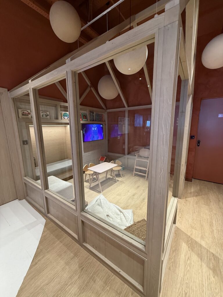 Glass-walled children's play room with TV and table
