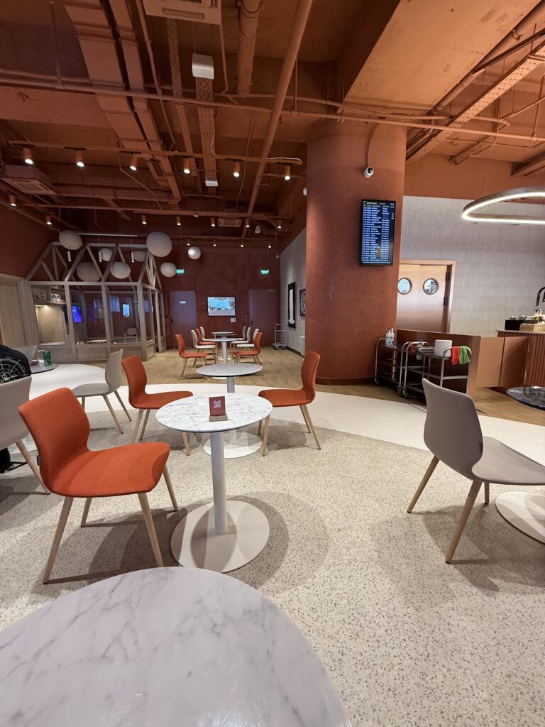 Seating area with orange chairs and marble tables