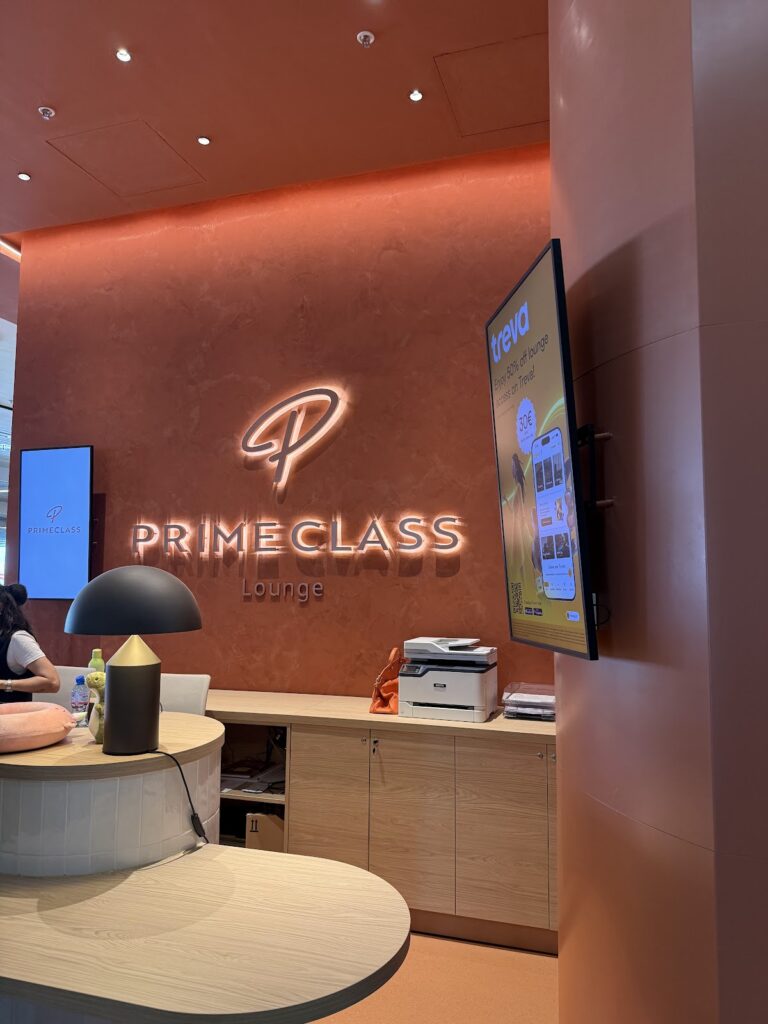 Primeclass Lounge reception desk with illuminated logo signage