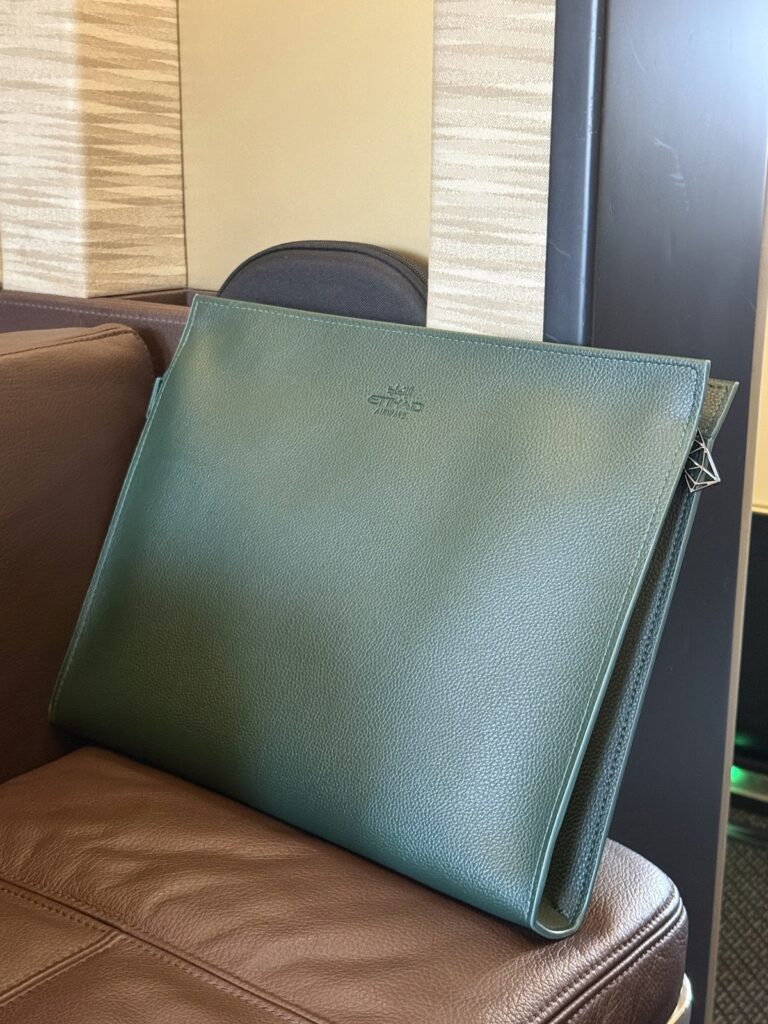 Etihad green leather amenity pouch on first class seat