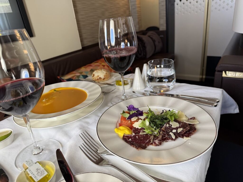 First class dining with beef carpaccio and red wine