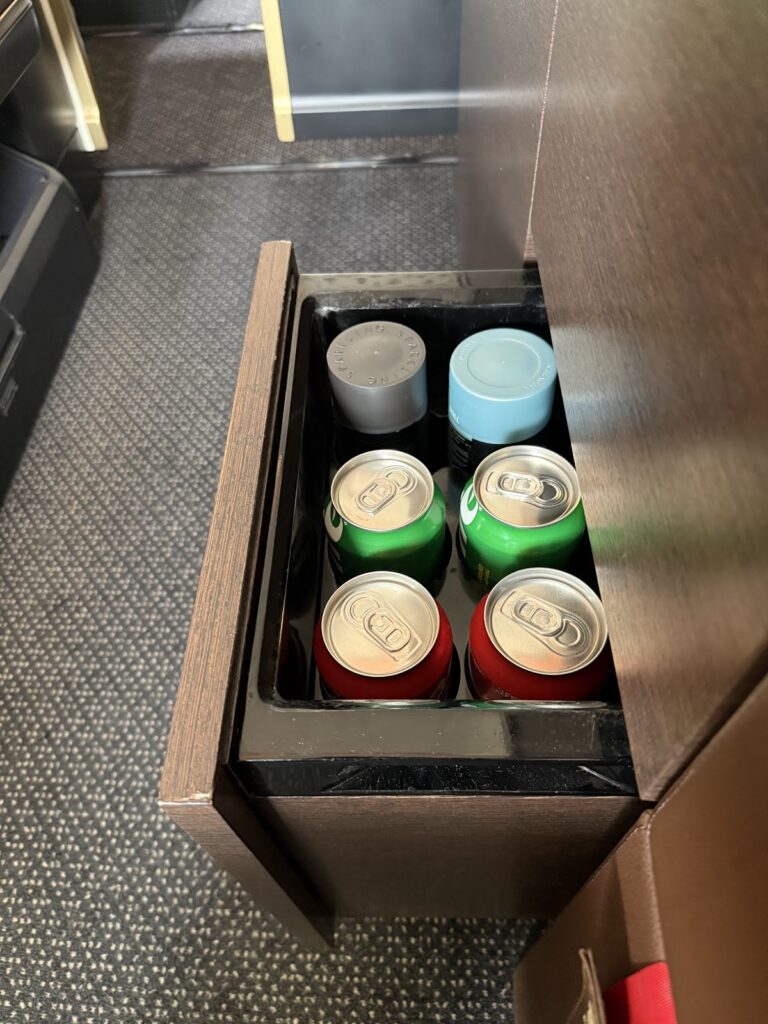 In-seat minibar drawer with soft drinks and water