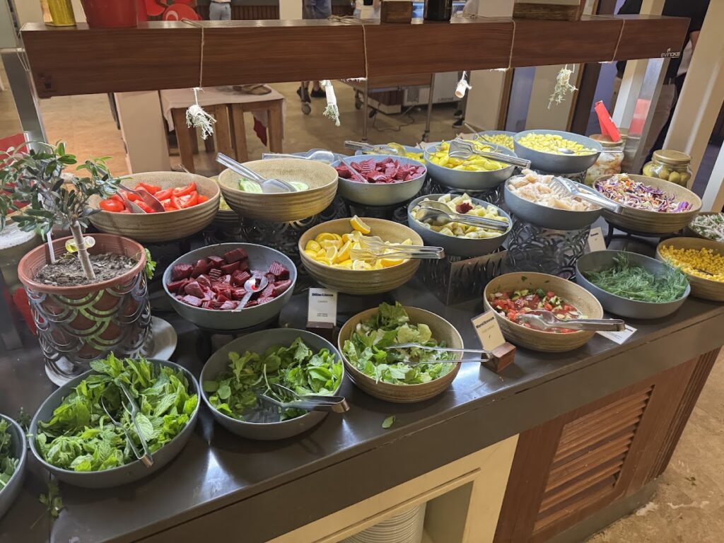 Buffet spread with fresh salads, vegetables, and appetizers