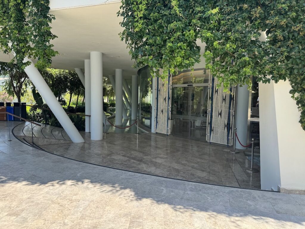 Modern architecture with ivy-covered columns and glass doors