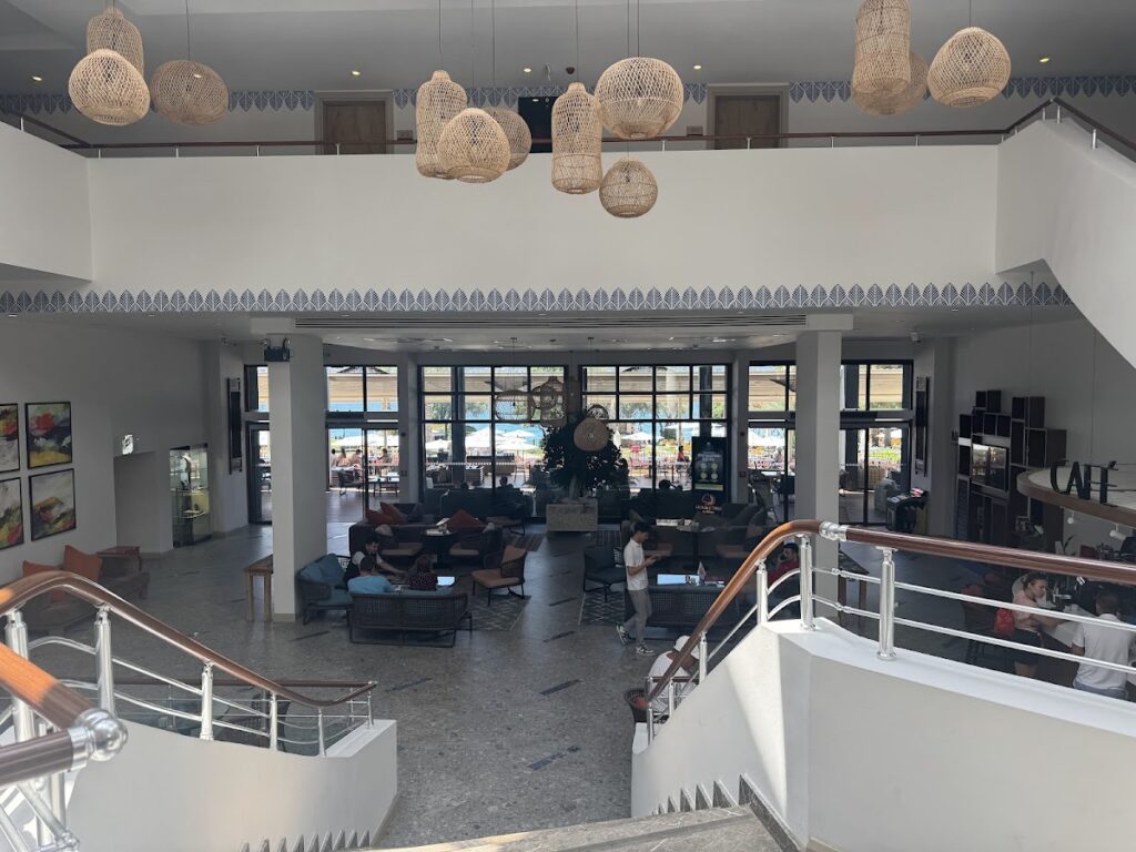 Hotel lobby with hanging pendant lights and glass doors overlooking