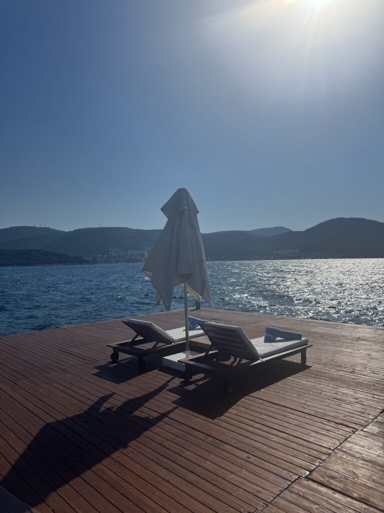 Beachfront loungers with umbrella overlooking Bodrum bay