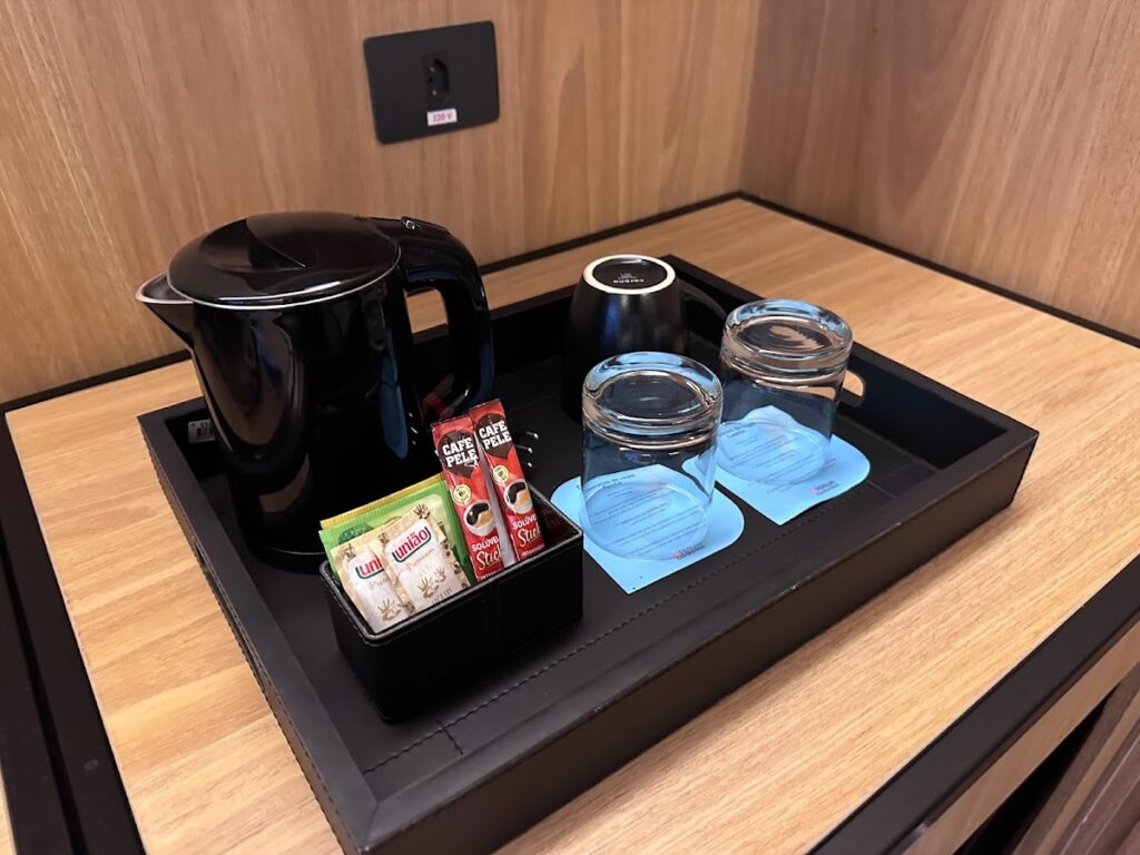 In-room coffee station with kettle, glasses, sachets