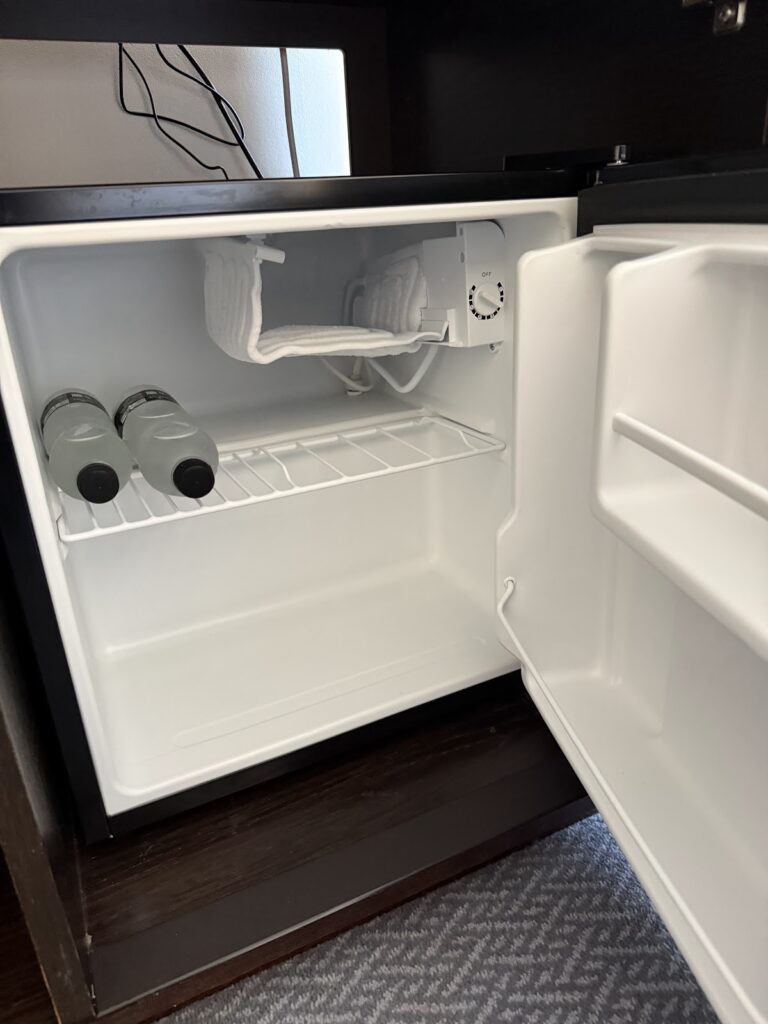 Hotel room mini refrigerator with complimentary water bottles