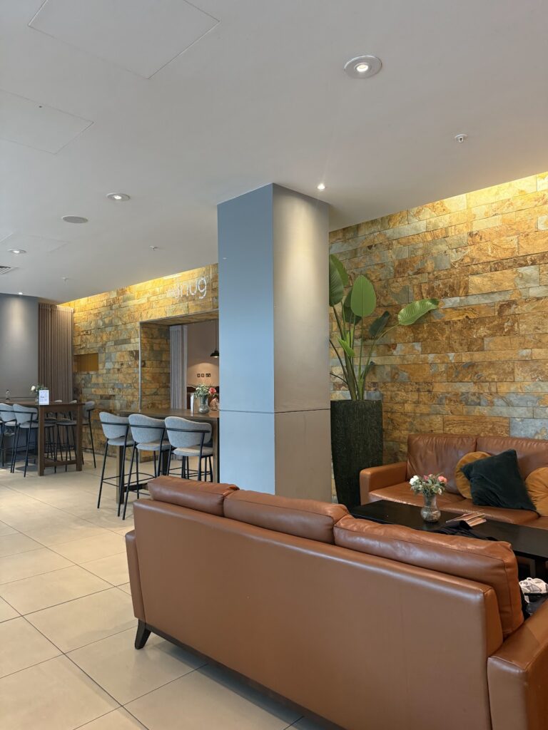 Hilton Canary Wharf lobby with leather seating and stone accent