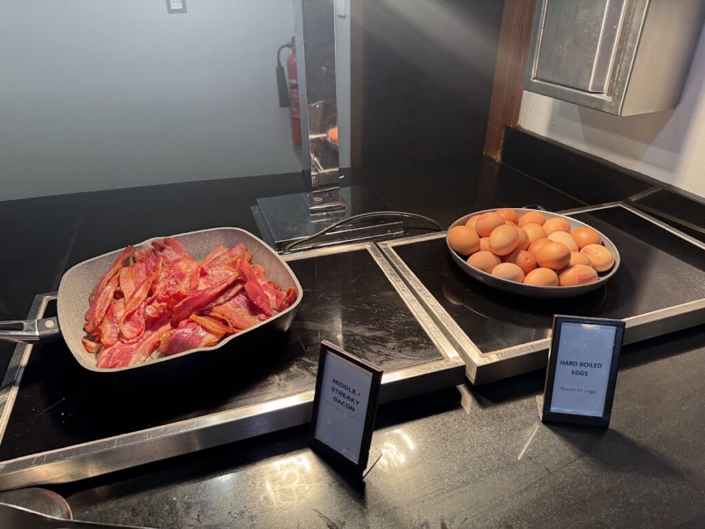 Breakfast hot items bacon and hard boiled eggs in warming