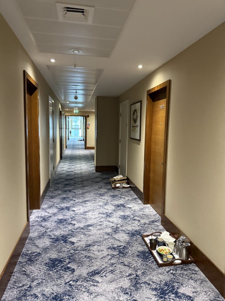Hilton Canary Wharf corridor with dated carpet and wood doors