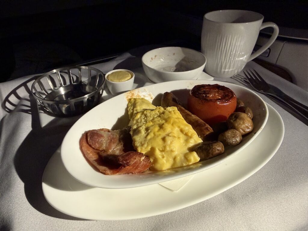 Breakfast plate with omelet, bacon, mushrooms, tomato.