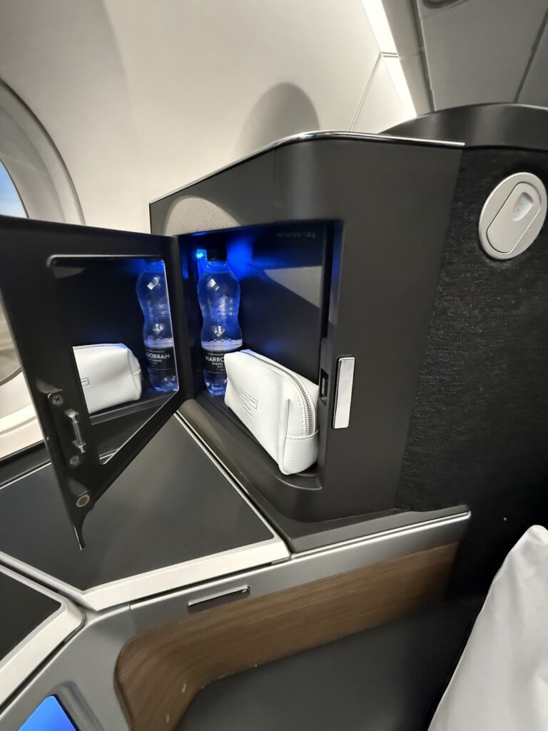 Club Suite amenity kit and water bottles in storage compartment