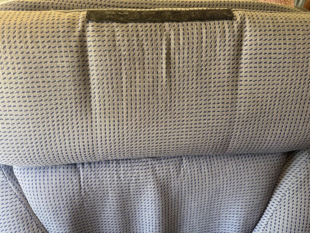 Close-up of grey business class seat fabric and amenities