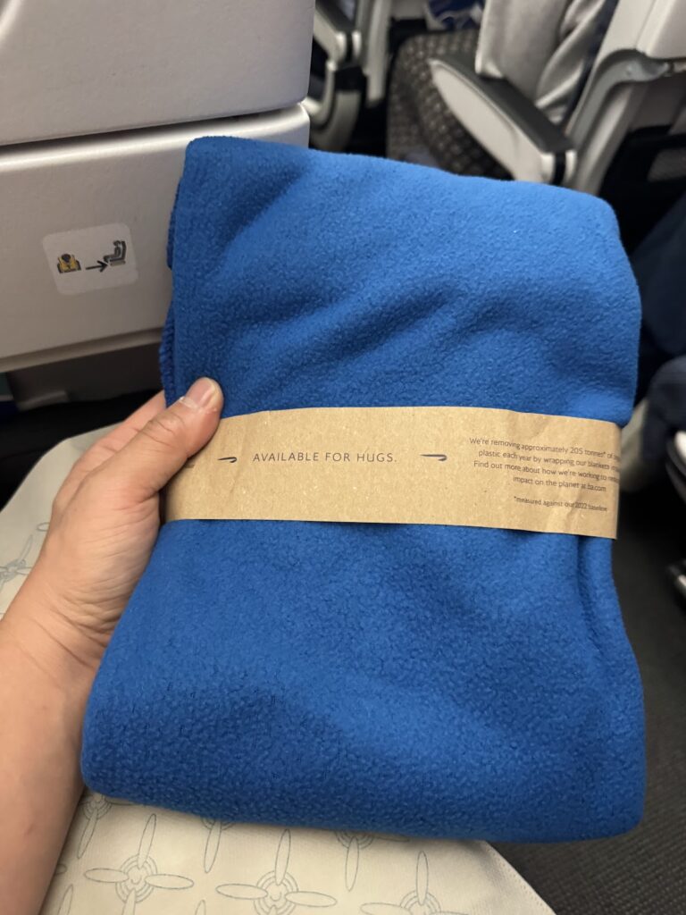 Blue amenity blanket with sustainable packaging from British Airways